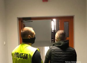 Policjant prowadzi zatrzymanego mężczyznę