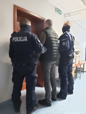 Dwóch policjantów z zatrzymanym mężczyzną