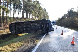 Biały bus leży na boku na drodze