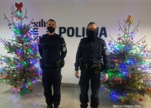 Dwóch Policjantów stoi obok choinek - pozują do zdjęcia