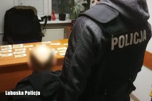 Policjant przeprowadza czynności z zatrzymanym