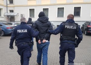 Policjanci prowadzą zatrzymanego