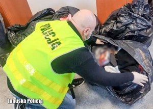 Policjant sprawdzający zawartość worków