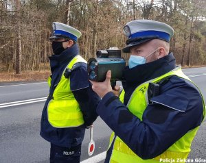 Dwóch funkcjonariuszy kontroluje prędkość na drodze