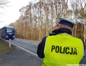 Funkcjonariusz policji mierzący prędkość przejeżdżających pojazdów