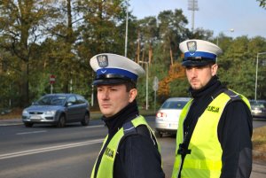 Dwóch policjantów na tle jezdni z samochodami