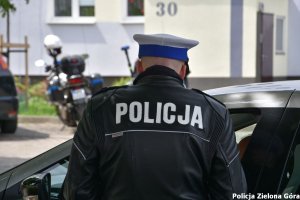 Policjant w skórzanej kurtce z napisem policja