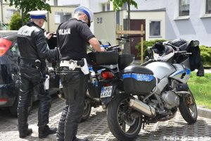 Dwóch policjantów stojący przy motocyklach służbowych