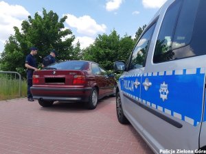 Policjanci przy czerwonym bmw