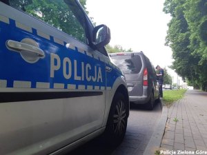 Policjant kontrolujący kierowce szarego samochodu