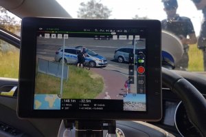 Obraz z kamery drona przedstawiający policjanta rozmawiającego z rowerzystą
