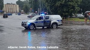 Radiowóz blokujący wjazd na zalaną ulicę