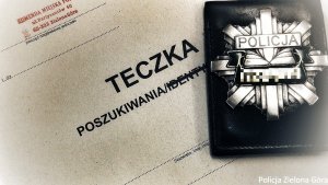 zdjęcie policyjnej odznaki - gwiazdy leżącej na szarej teczce z napisem &quot;Teczka poszukiwania&quot;