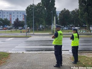 Dwójka policjantów stojąca przed przejściem dla pieszych.