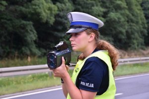 Policjantka mierząca prędkość nadjeżdżających samochodów.