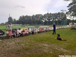 Policjant wraz z psem policyjnym obok dzieci.