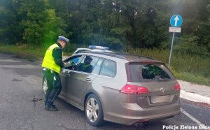 Policjant kontroluje zatrzymany samochód