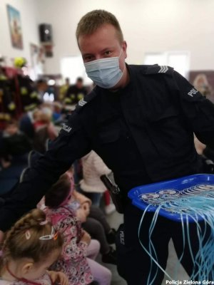 Policjant rozdający upominki dla dzieci.
