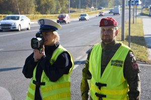 Policjantka Ruchu Drogowego z laserowym miernikiem prędkości i żołnierz żandarmerii wojskowej