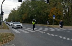 Policjantka Ruchu Drogowego kieruje ruchem na przejściu dla pieszych