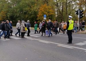 Policjantka Ruchu Drogowego wstrzymuje ruch żeby piesi mogli przejść