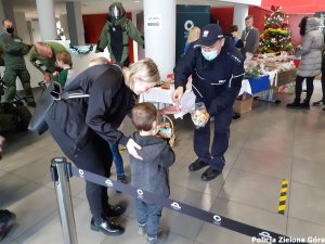 Policjant wręcza dziecku upominek.