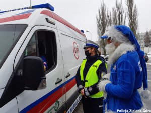 Policjantka z Polikołajem stoją obok karetki