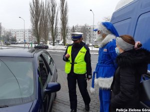 Polikołaj wraz z policjantką oraz cywilem stoją obok samochodu