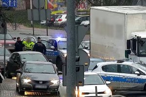 Spora ilość samochodów oraz dwójka policjantów rozmawiających z jednym z kierowców.