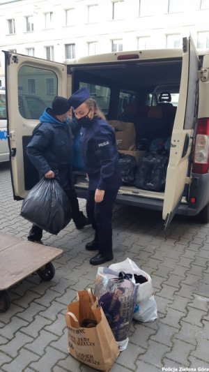 Policjanci pakujący ciepłą odzież do busa.