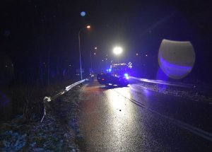 Straż pożarna stojąca przed samochodem który został rozbity.