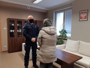 Policjant przyjmujący podziękowania od seniorki za zaangażowanie i skuteczność.