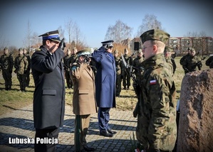 Policjanci salutują wraz z wojskowymi.