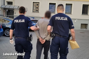 Dwóch policjantów wraz z oskarżonym mężczyznom.