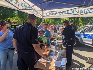 Policjanci przy straganie wraz z grupą cywili.