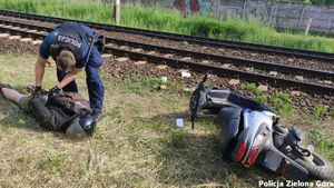 Policjant skuwa podejrzanego a obok leży motor poszukiwanego.