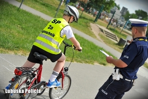 Policjant wraz z chłopcem na rowerze.