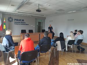 Policjant rozmawia z grupą młodzieży.