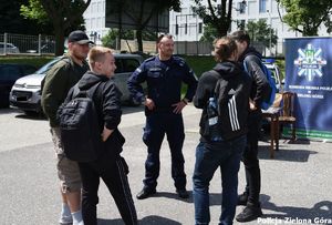 Policjant rozmawia z grupą nastolatków.