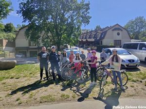 Rowerzyści stojący obok policjantki Ruchu drogowego.