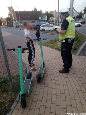 Policjant Wydziału Ruchu Drogowego podejmujący czynności służbowe wobec kierującego hulajnogą elektryczną.