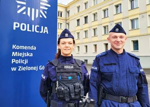 Dwójka policjantów a w tle napis Komenda Miejska Policji.