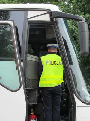 Policjant kontroluje autobus wycieczkowy.