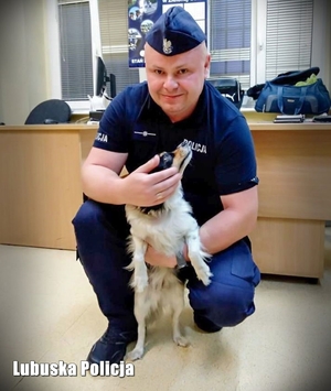 Kolejne zdjęcie policjanta z psem którego uratował.