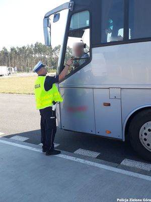 Policjant sprawdza trzeźwość kierowcy autobusu.