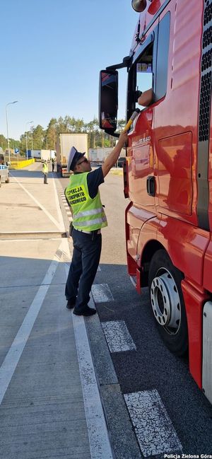 Policjant bada trzeźwość kierowcy pojazdu.