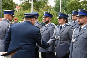 Policjant ściska dłoń innej policjantki.