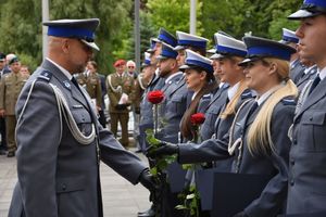 Policjant wręcz różę policjantce.