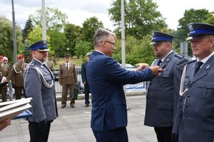 Prezydent miasta wręcza medal policjantowi.