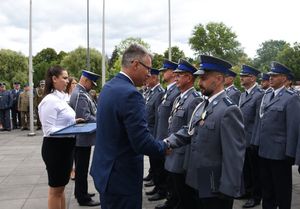 Policjant ściska dłoń prezydenta miasta.